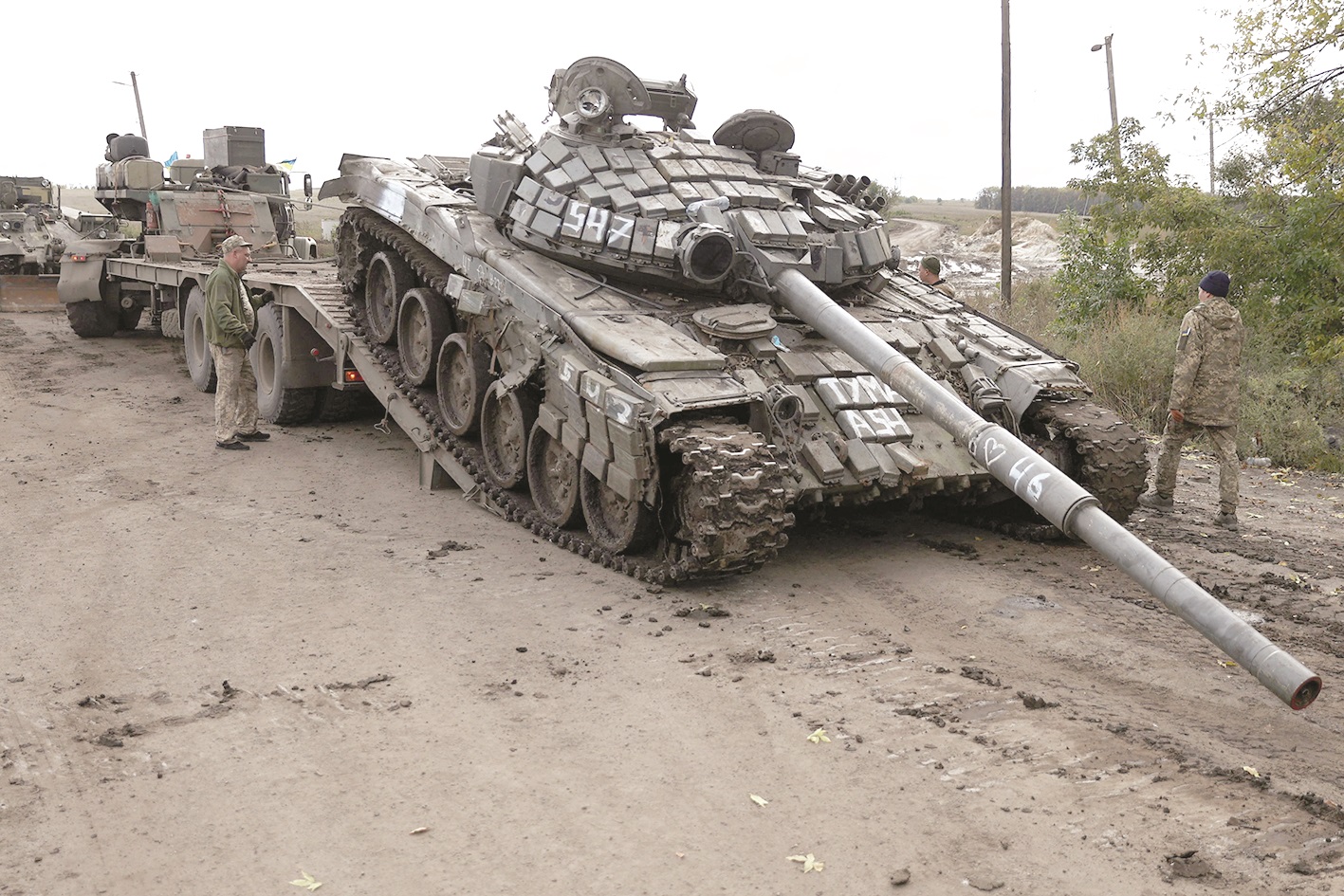 A Russian T-72 tank is loaded on a truck by Ukrainian soldiers outside the town of Izyum, as the Ukrainian counter-offensive seized most of the northeast Kharkiv region.