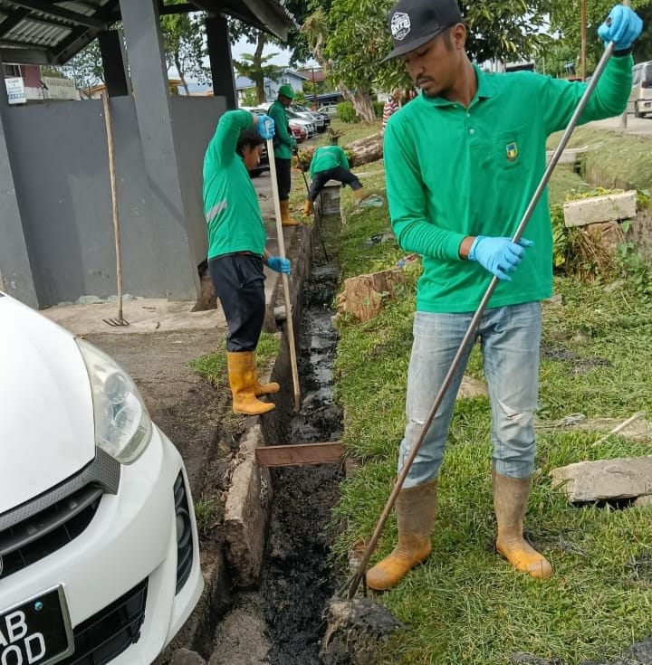 The DCU team cleans the drain behind the  bin-centre for the Kepayan Commercial Centre.
