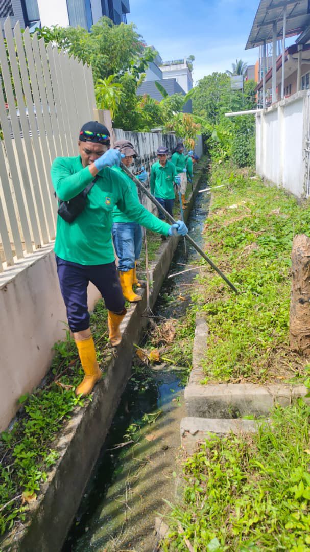Rakes and hoes were used to clear the weeds and mud from this backyard drain in Taman Sinar.
