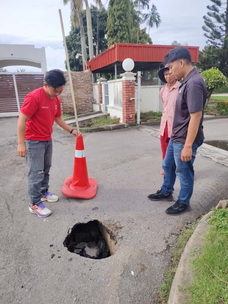 A traffic cone was placed over the deep pothole which had formed on Jalan Basel.