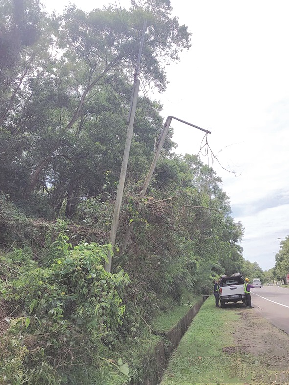 Celcom Timur staff tried to return the leaning pole on Jalan Pintas to an upright position as much as possible.