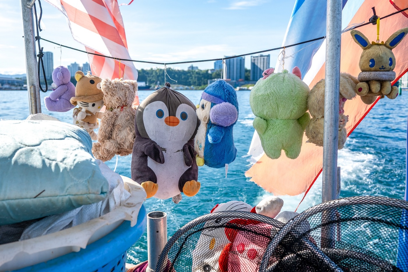 A line of salvaged plush toys hangs from the boat’s railing. These non-recyclable objects are kept by the crew as souvenirs, with many of them playfully named after MRF team members.