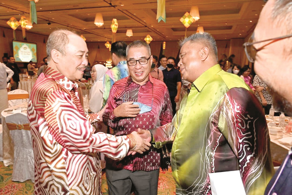 Hajiji (left) wishing “Selamat Hari Raya” to Yusaini Sidek of Evolve Reits Berhad,  one of the invited guests from Kuala Lumpur, during the event. 