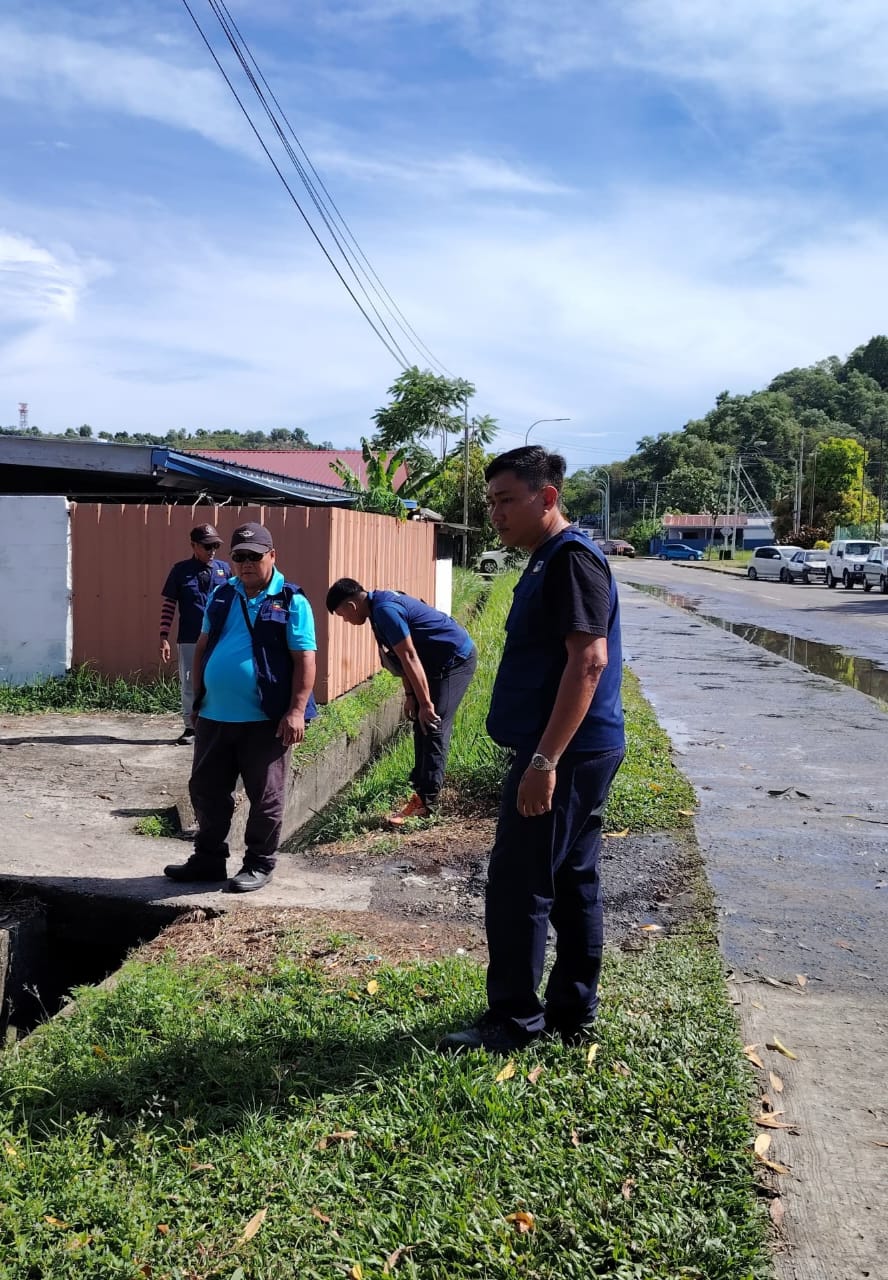 KAKITANGAN DBKK memeriksa keadaan longkang di Taman  Kepayan Ridge ini.