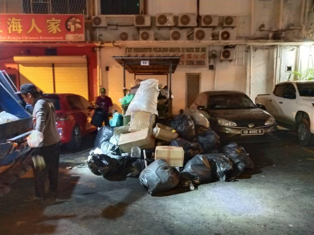 PEKERJA DBKK membersihkan sampah dari rumah sampah di Lorong Bank.